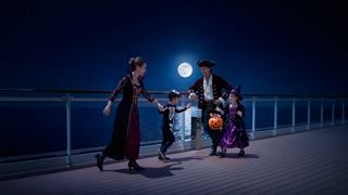 A family celebrates Halloween on the deck beneath the moonlight | MSC Cruises