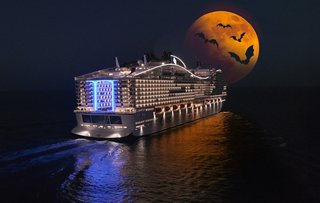 Das Schiff von MSC Cruises segelt durch das nächtliche Meer mit einem strahlenden Mond im Hintergrund | MSC Cruises