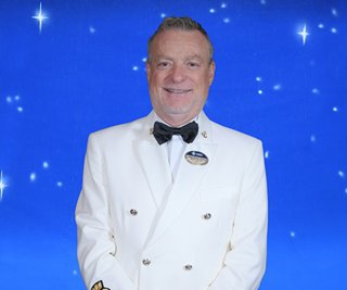 Capitano in uniforme bianca ufficiale con distintivi sulla spilla | MSC Cruises