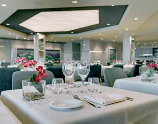 Stylish dining area with elegant tables and flowers in a warm atmosphere | MSC Cruises