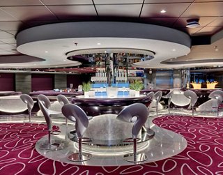 Bar moderne avec des tables et des chaises élégantes, offrant une atmosphère chaleureuse pour les rencontres | MSC Croisières