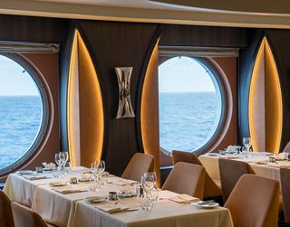 Restaurante luminos con ventanas redondas y mesas cómodas con vistas al mar | MSC Cruceros
