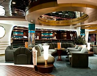 A stylish seating area in La Prua Piano Bar features sofas and armchairs, inviting relaxation and conversation | MSC Cruises