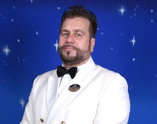 Crew member in white uniform standing with formal posture | MSC Cruises