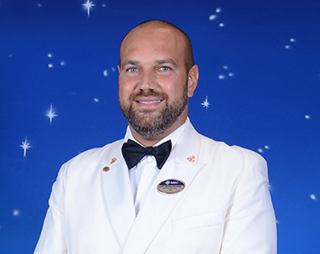 Crew officer in uniform with epaulettes and name tag | MSC Cruises