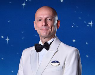 Crew member in formal attire posing for portrait | MSC Cruises