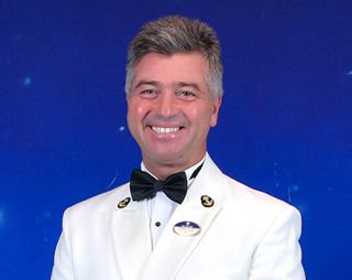 Officer in white uniform looking at the camera | MSC Cruises
