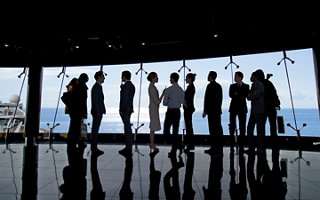 A group of people stands by a window with a sea view, sharing ideas and inspiration | MSC Cruises