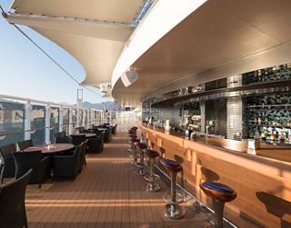A stylish bar area with seating and a view, inviting guests to relax and enjoy refreshing drinks | MSC Cruises