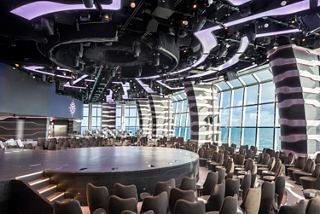 Carousel Lounge on MSC Grandiosa featuring a central stage and panoramic sea views | MSC Cruises