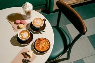 Table with cups of coffee and pastries in a welcoming café setting | MSC Cruises