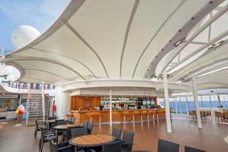 Outdoor bar with stylish seating and sea views on a cruise ship deck | MSC Cruises
