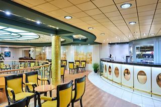 Modern café on MSC Armonia features comfortable seating, a bar, and a piano for guests | MSC Cruises