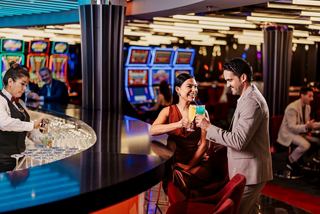 Guests enjoy drinks at the casino bar surrounded by a lively ambiance | MSC Cruises