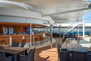 Outdoor bar and seating area on MSC Orchestra with sea views and a welcoming atmosphere | MSC Cruises