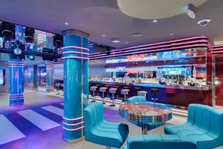 The Garage Club bar on MSC Seaside features inviting seating and vibrant lighting ambiance | MSC Cruises