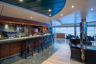 Contemporary bar and inviting seating area with a scenic view of the sea | MSC Cruises
