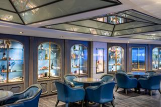 Il Grappolo d'Oro bar on MSC Poesia features inviting seating and displays of wine bottles and glasses | MSC Cruises