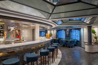 Bar with stylish seating and large windows aboard MSC Poesia inviting relaxation | MSC Cruises
