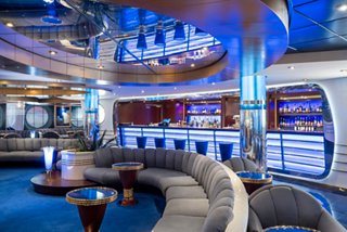 Spacious bar with comfortable sofas and vibrant blue décor for relaxation onboard | MSC Cruises