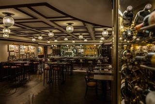 L'Atelier Bar & Art on MSC Virtuosa features inviting tables and bottles in a warm setting | MSC Cruises