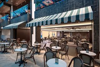 Entrance to L'Atelier du Voyageur restaurant on MSC Euribia with tables and chairs | MSC Cruises
