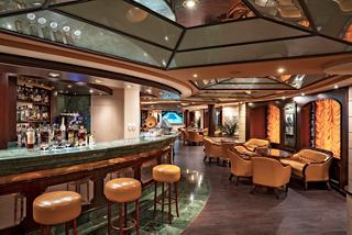 Bar and sitting area on MSC Orchestra with comfortable armchairs and tables | MSC Cruises
