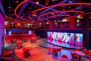 Stylish lounge with stage and seating area on a cruise ship, welcoming ambiance | MSC Cruises