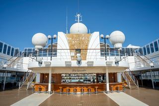 Outdoor bar with wooden counter and elegant modern features on a cruise ship | MSC Cruises