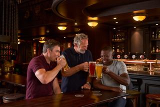 Three men enjoy drinks and laughter together at Masters of the Sea bar onboard | MSC Cruises