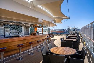 Outdoor bar area on the ship with comfortable seating and views of the sky and sea | MSC Cruises