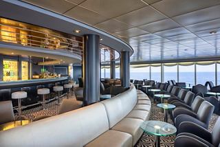 Contemporary lounge bar with comfortable seating and sea views for relaxation and entertainment | MSC Cruises
