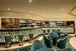 Spacious bar with armchairs and tables in the lounge area on MSC Preziosa | MSC Cruises