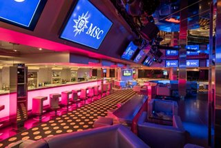R32 Disco bar on MSC Orchestra featuring vibrant lighting and a spacious seating area | MSC Cruises