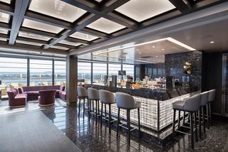 Modern lounge featuring a bar and comfortable seating overlooking the sea | MSC Cruises