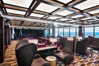 Seaview Lounge offers seating, a stage with piano and expansive windows overlooking the sea | MSC Cruises