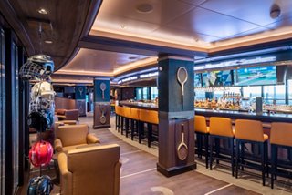 Inviting sports bar with cozy seating, a long bar counter and multiple screens for entertainment | MSC Cruises
