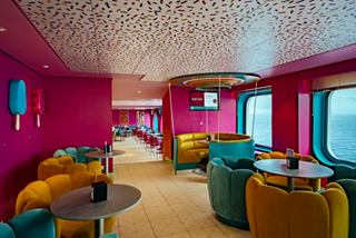 Inviting lounge with vibrant seating and sea views through portholes on MSC World Europa | MSC Cruises