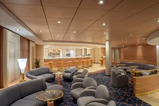 Spacious lounge featuring a bar and comfortable seating for relaxation and socializing onboard | MSC Cruises