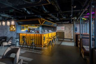 The Box Bar features a yellow bar counter and seating for a welcoming social experience | MSC Cruises