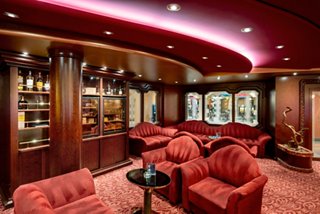 Inviting lounge with red armchairs and wooden shelves, perfect for relaxation and conversation | MSC Cruises