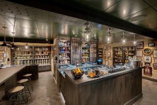 The Gin Project bar on MSC World Europa features a welcoming counter, bottles and inviting seating | MSC Cruises