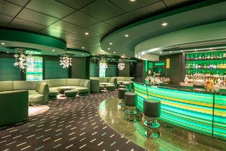 Green bar with cozy sofas and tables in the lounge area on MSC Preziosa | MSC Cruises