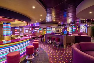 The Purple Jazz Bar features cozy seating areas, a bar counter and vibrant lighting | MSC Cruises