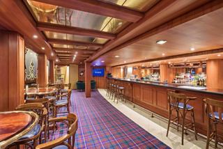 Warm bar with wooden furniture and inviting seating on MSC Armonia | MSC Cruises