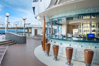 Outdoor bar on MSC Divina with seating and a view of the sea | MSC Cruises