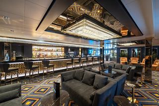 Bar and lounge area featuring modern seating, table and an elegant bar counter | MSC Cruises