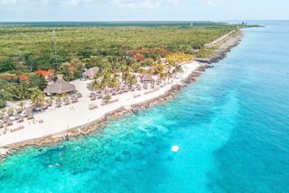 Cozumel coastline with white sand beach, turquoise sea and lush greenery from above | MSC Cruises
