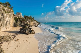 Caribbean shore with Maya ruins atop cliffs, turquoise sea and sandy beach in Tulum | MSC Cruises