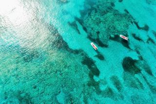 Clear turquoise waters with boats by the reef at Grand Turk Island in the Caribbean | MSC Cruises